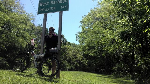 Paul and bike under West Baraboo sign