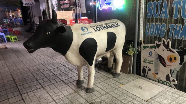 Statue of cow in front of shop.