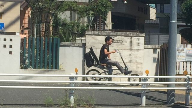 A man on a recumbent bicycle.