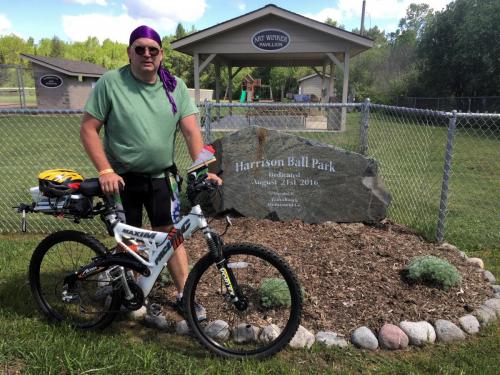 Paul and bike in front of sign