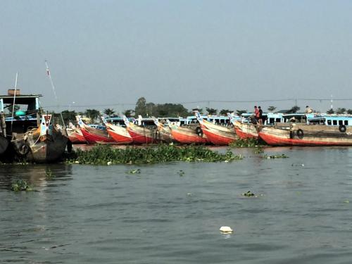 fishing boats lined up on Sông Hậu River.