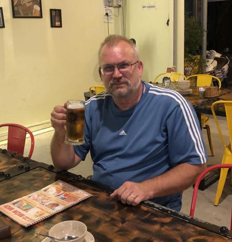 Paul lifting a glass after a long day of riding.